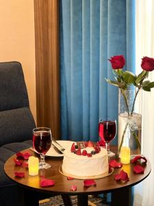 a table with a cake and two glasses of wine at Elite Alnokhba - Alkhalidiyyah in Medina