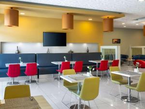 a dining room with tables and red chairs at Ibis Kayseri in Kayseri