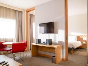 um quarto de hotel com uma cama e uma secretária com uma mesa em Novotel Gaziantep em Gaziantep