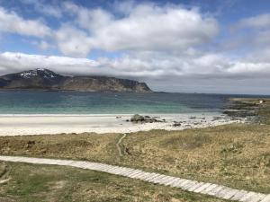 a view of a beach with a mountain in the distance at Hjertet av Ramberg in Ramberg