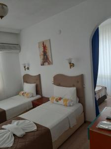 a room with two beds and a table at Sevo Hotel in Ayvalık