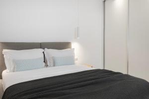 sypialnia z dużym łóżkiem z niebiesko-białymi poduszkami w obiekcie Ornos Vibes 2 w mieście Ornos