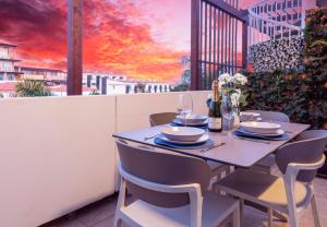 een tafel en stoelen op een balkon met een zonsondergang bij Barista Homes in San Miguel de Abona