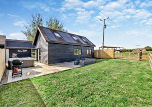 Popps Barn في Feering: منزل صغير على السطح مع لوحات شمسية