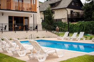 a group of lounge chairs next to a swimming pool at Apartamenty Kazimierz Dolny in Kazimierz Dolny