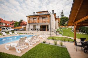 a house with a pool and a group of chairs at Apartamenty Kazimierz Dolny in Kazimierz Dolny