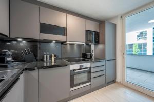 a kitchen with stainless steel appliances and a large window at EXQUIS 2BR Design Apartment LOUIS I Parking I Balcony I Mercedes-Benz I Family-friendly in Böblingen