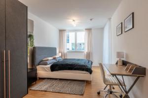 a bedroom with a bed and a desk and a desk at EXQUIS 2BR Design Apartment LOUIS I Parking I Balcony I Mercedes-Benz I Family-friendly in Böblingen