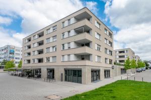 an apartment building on a street with a lawn at EXQUIS 2BR Design Apartment LOUIS I Parking I Balcony I Mercedes-Benz I Family-friendly in Böblingen