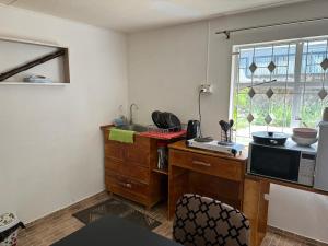 a kitchen with a desk and a microwave at Chez Hedley Résidence : Couple/Business in Pointe aux Sable