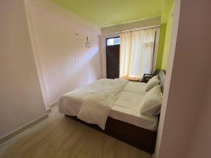 シムラーにあるDream Home Homestayの窓付きのベッドがある小さな寝室