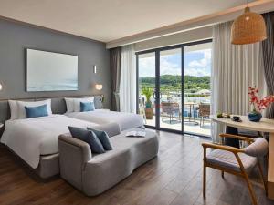 une chambre d'hôtel avec un lit et un canapé dans l'établissement Premier Residences Phu Quoc Emerald Bay Managed by Accor, à Duong Dong