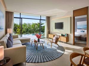 a living room with a couch and a table at Premier Residences Phu Quoc Emerald Bay Managed by Accor in Phu Quoc