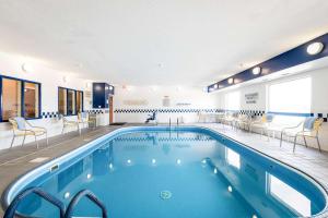 una piscina in un hotel con sedie e tavoli di SureStay Plus Hotel by Best Western Minot a Minot