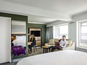 um homem e uma mulher num quarto de hotel com uma cama em Mercure Bedford Centre Hotel em Bedford