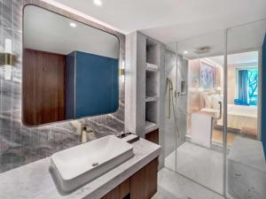 ein Bad mit einem Waschbecken und einem Spiegel in der Unterkunft Radisson Blu Hotel GRT, Chennai International Airport in Chennai