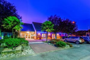 a house with cars parked in a parking lot at Comfort Hotel Orleans Saran in Saran