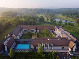 - une vue aérienne sur une maison avec une piscine dans l'établissement Le Domaine des Vanneaux Golf et Spa Mgallery, à LʼIsle-Adam