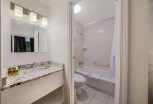 a bathroom with a sink and a toilet and a tub at SureStay Hotel by Best Western Rossland Red Mountain in Rossland