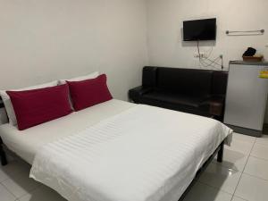 una camera da letto con un letto con cuscini rossi e una sedia di D Heart Homestay a Bangkok