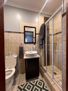 a bathroom with a toilet and a sink and a shower at Bluestream Villas in Pretoria