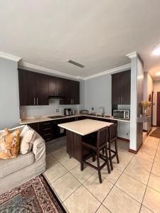 a large kitchen with a table and a couch at Bluestream Villas in Pretoria
