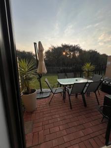 a patio with a table and chairs and an umbrella at Bluestream Villas in Pretoria +5 photos