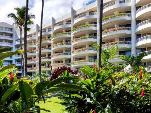 een groot appartementencomplex met planten ervoor bij Fairmont Kea Lani, Maui in Wailea