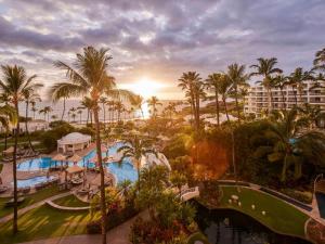 een uitzicht op een resort met een zwembad en palmbomen bij Fairmont Kea Lani, Maui in Wailea