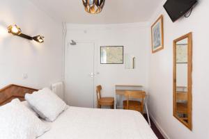 - une chambre avec un lit, un miroir et une table dans l'établissement Ideal Hotel, à Paris