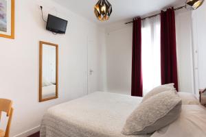 Habitación blanca con cama y espejo en Ideal Hotel en París
