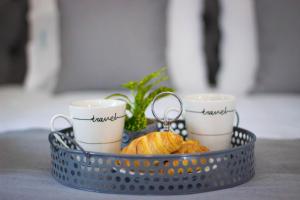 a basket with two cups and a pair of scissors at Potamos Studios by GERANI in Órmos