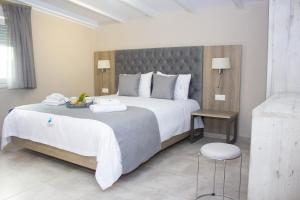 a hotel room with a large bed and a chair at Potamos Studios by GERANI in Órmos