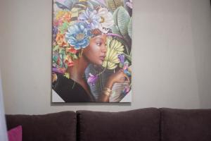 a painting of a woman with flowers on a wall at Potamos Studios by GERANI in Órmos