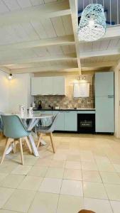 Una cocina con mesa y sillas y un refrigerador. en Gentile Cottege, en Matino
