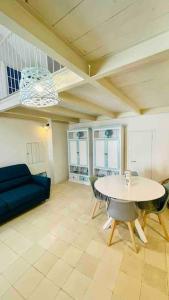 Una sala de estar con una mesa y un sofá azul. en Gentile Cottege, en Matino