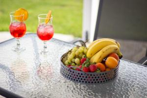 a bowl of fruit on a table with two drinks at Potamos Studios by GERANI in Órmos