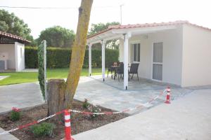 a white house with a patio with a table at Potamos Studios by GERANI in Órmos
