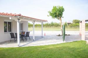 a pavilion with a table and chairs on a patio at Potamos Studios by GERANI in Órmos
