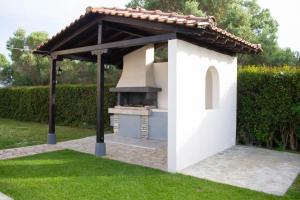 a barbecue under a gazebo in a garden at Potamos Studios by GERANI in Órmos