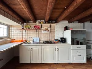 une cuisine avec des armoires blanches et un réfrigérateur blanc dans l'établissement Terrace on the sea, à Syracuse