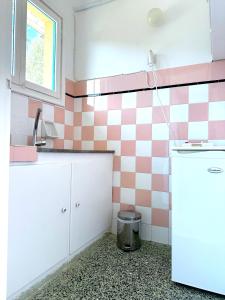 a kitchen with pink and white tiles on the wall at Bouros Seaview Farm in Karistos +17 photos