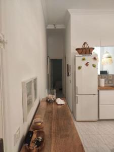 una cucina con tavolo in legno e frigorifero bianco di Acogedor apartamento junto al mar a Puertito de Güímar