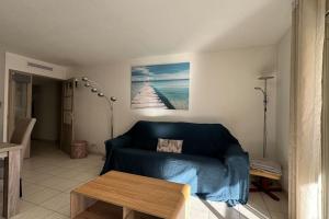 a living room with a blue couch and a table at Nice Proche Mer in Nice +10 photos
