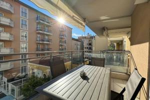 a balcony with a wooden table and chairs on a building at Nice Proche Mer in Nice