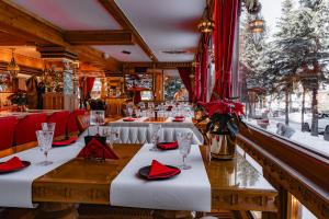 a restaurant with a table with red napkins and glasses at Mountain Diamond Resort in Zakopane