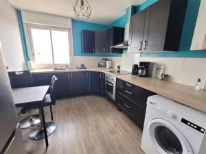 a kitchen with blue cabinets and a washing machine at Appartement T5 avec 3 chambres in Brest