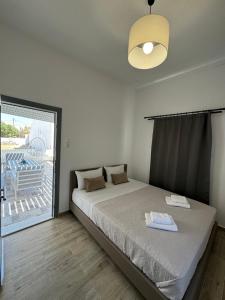 a bedroom with a bed and a large window at House on the beach Agia Anna Naxos in Agia Anna Naxos