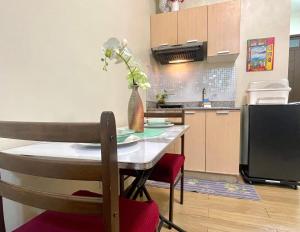 a kitchen with a table with a vase of flowers on it at Emma's Comfy Space in Manila