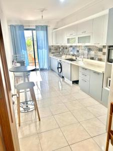 une cuisine avec des armoires blanches et une table et des chaises dans l'établissement Prodige meublées, à Abidjan